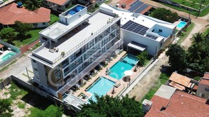 A modern building with a rooftop pool, solar panels, and a large glass facade. - Acqua Beach Residence (Tamandaré)