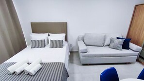 A hotel room with a bed, a sofa, and a chair. - Acqua Beach Residence (Tamandaré)