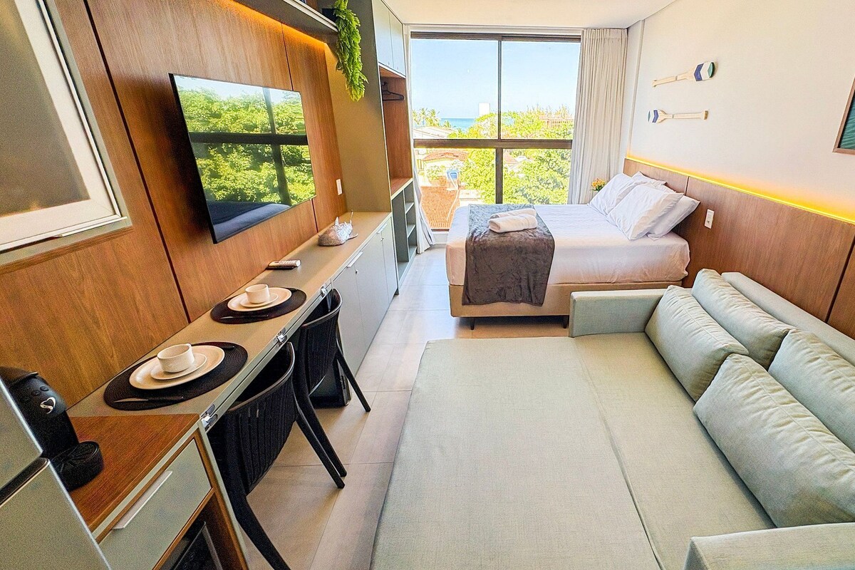Una stanza compatta con un letto, un divano, una TV e un'area pranzo.