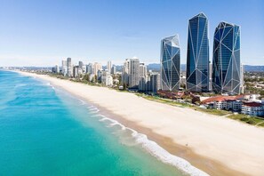 A coastal cityscape with modern skyscrapers, a sandy beach, and a clear blue sea. - Monaco Escape Seaside Stay near Dining and Nightlife (Surfers Paradise)