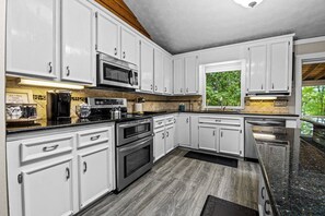 A kitchen with white cabinets, a built-in oven, a microwave, and a coffee station. - Lake Lanier Escape - Gainesville Lakefront stay (Gainesville)