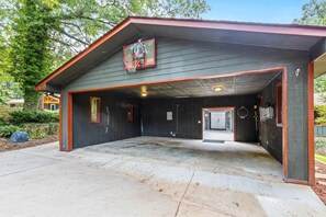 Un garage fermé avec un panier de basketball, une porte donnant sur le garage et un plancher en béton.