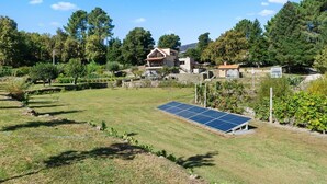 A house with a solar panel, a grassy yard, and trees. - Bed and Breakfast 'Piso Lua' with Mountain View and Heated Pool (Vila Real)