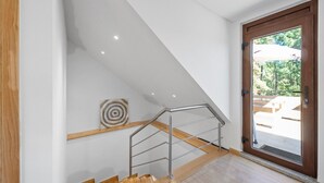 A modern interior with a wooden staircase, a metal handrail, and a door leading outside. - Bed and Breakfast 'Piso Lua' with Mountain View and Heated Pool (Vila Real)