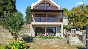 A two-story building with a balcony, stone walls, and a garden. - Bed and Breakfast 'Piso Sol' with Mountain View and Heated Pool (Vila Real)