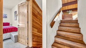 A bedroom with a wooden door, a bed with a red and black checkered blanket, and a small bench. - Tahoe Donner Getaway | Ski-In/Ski-Out Retreat (Truckee)