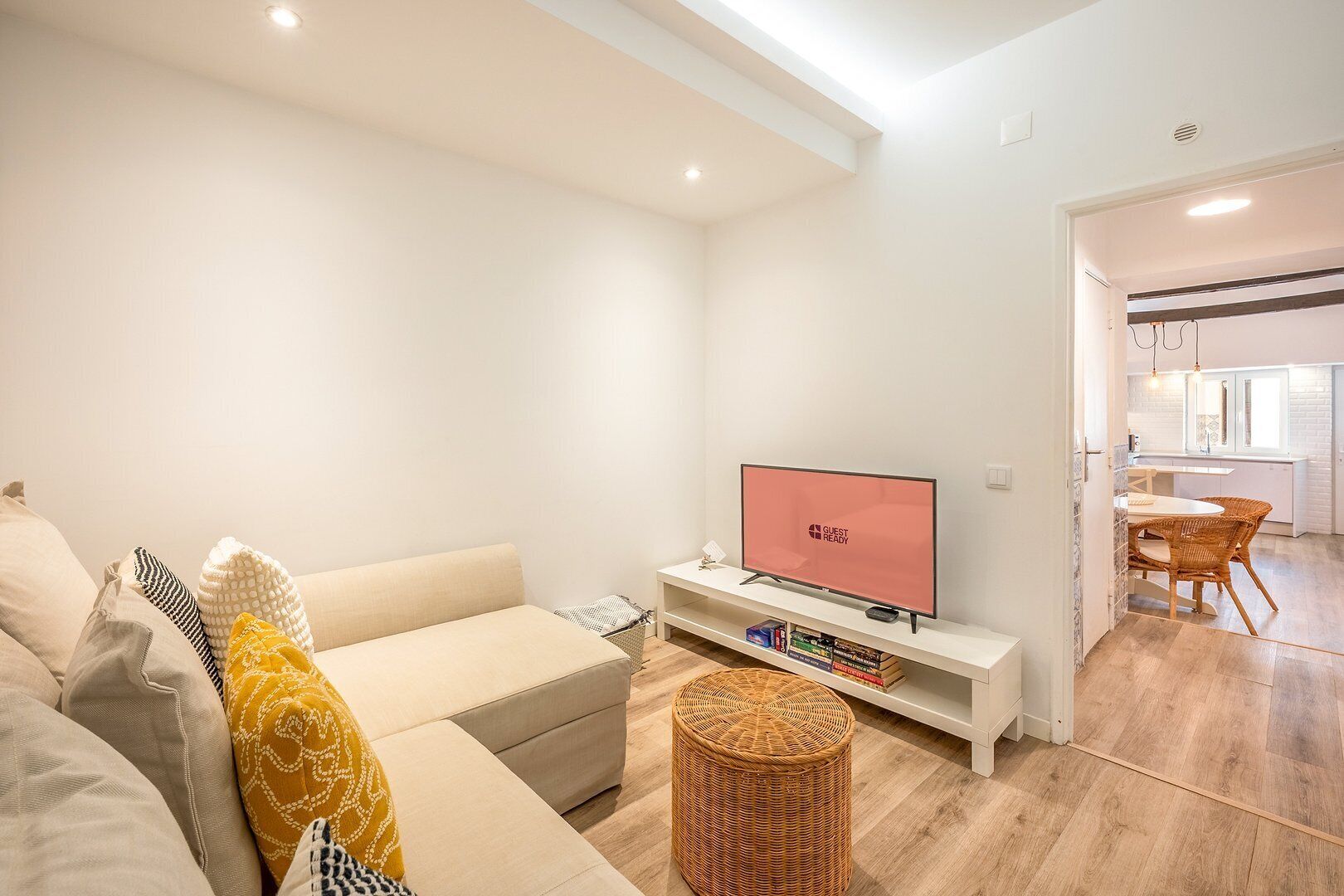 A modern living room with a sofa, a television, and a small table with books.