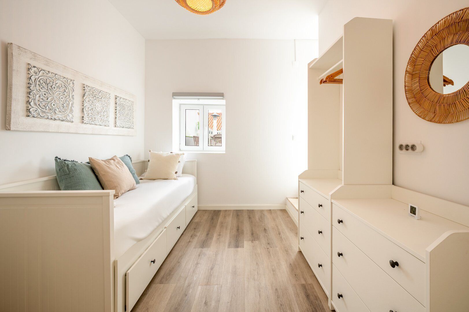 A bedroom with a bed, dresser, and a mirror.