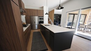 Cozinha moderna com armários de madeira, eletrodomésticos de aço inoxidável e uma ilha grande.
