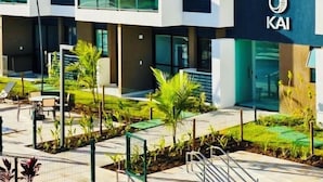 A modern multi-story hotel with balconies, a swimming pool, and outdoor seating. - Makia Beach Experience Resort - Muro Alto, Porto de Galinhas - B18 POOL FRONT (Ipojuca)