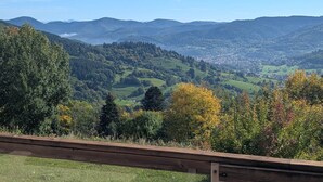 A scenic view of a valley with a town in the distance, surrounded by hills and trees. - Le Panorama with views of the Valley (Soultzeren)