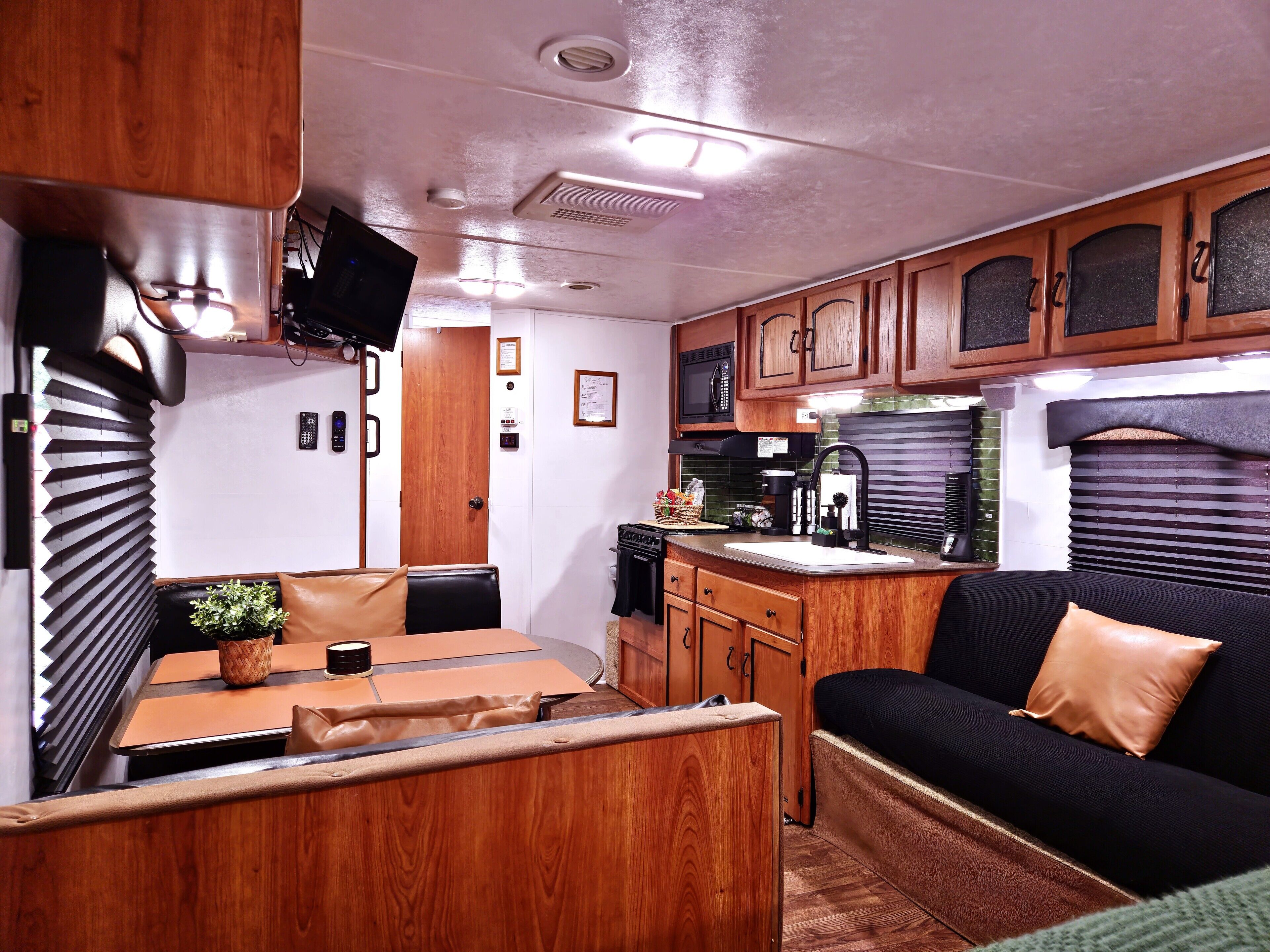 Interior compacto de una autocaravana con cocina americana, zona de comedor y espacio de estar.
