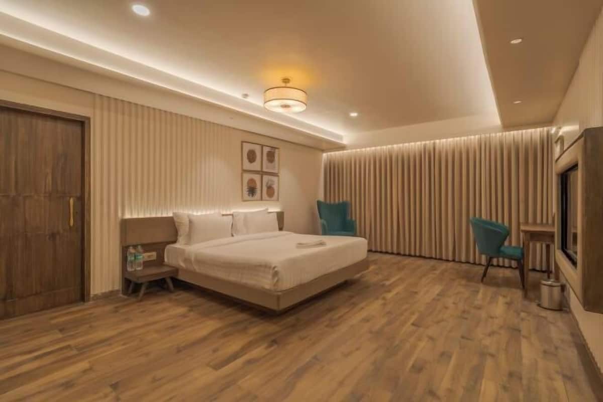 Une chambre d’hôtel moderne avec un grand lit, une table de chevet, une chaise et une armoire.