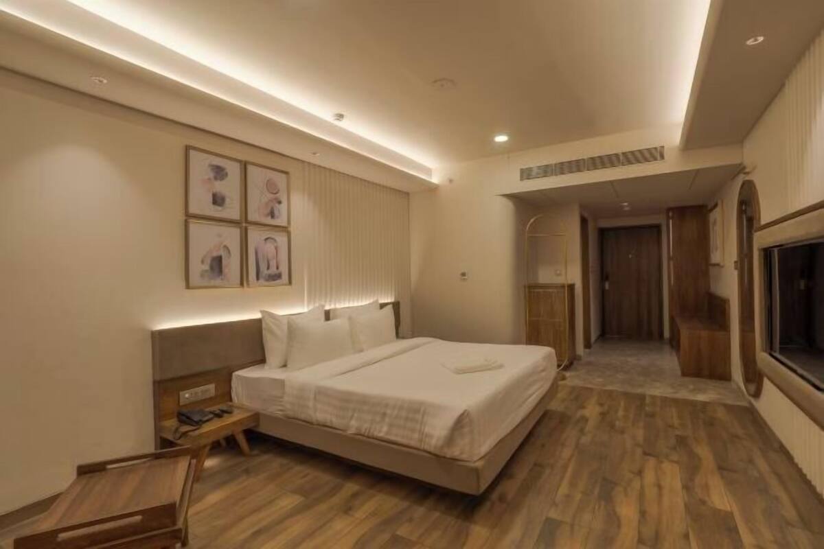 Une chambre d’hôtel avec un lit, une table de chevet et un téléviseur.