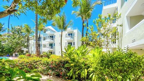 A resort with multiple-story buildings, a pool area, and lush greenery. - GO TO THE BEACH STAYS (Punta Cana)