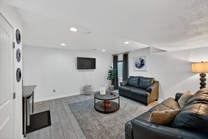 Una sala de estar moderna con un sof á, una mesa de centro, un televisor y una chimenea.