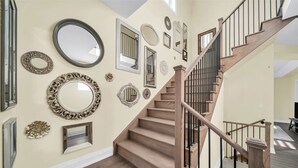 Una escalera de madera con barandilla de metal que sube a un segundo piso.