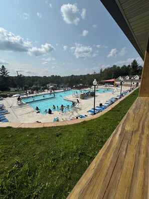 A swimming pool with multiple lanes, sun loungers, and a covered area. - Pocono Family Vacation Home/Pools/Lake access/Fire pit/Games (Tobyhanna)