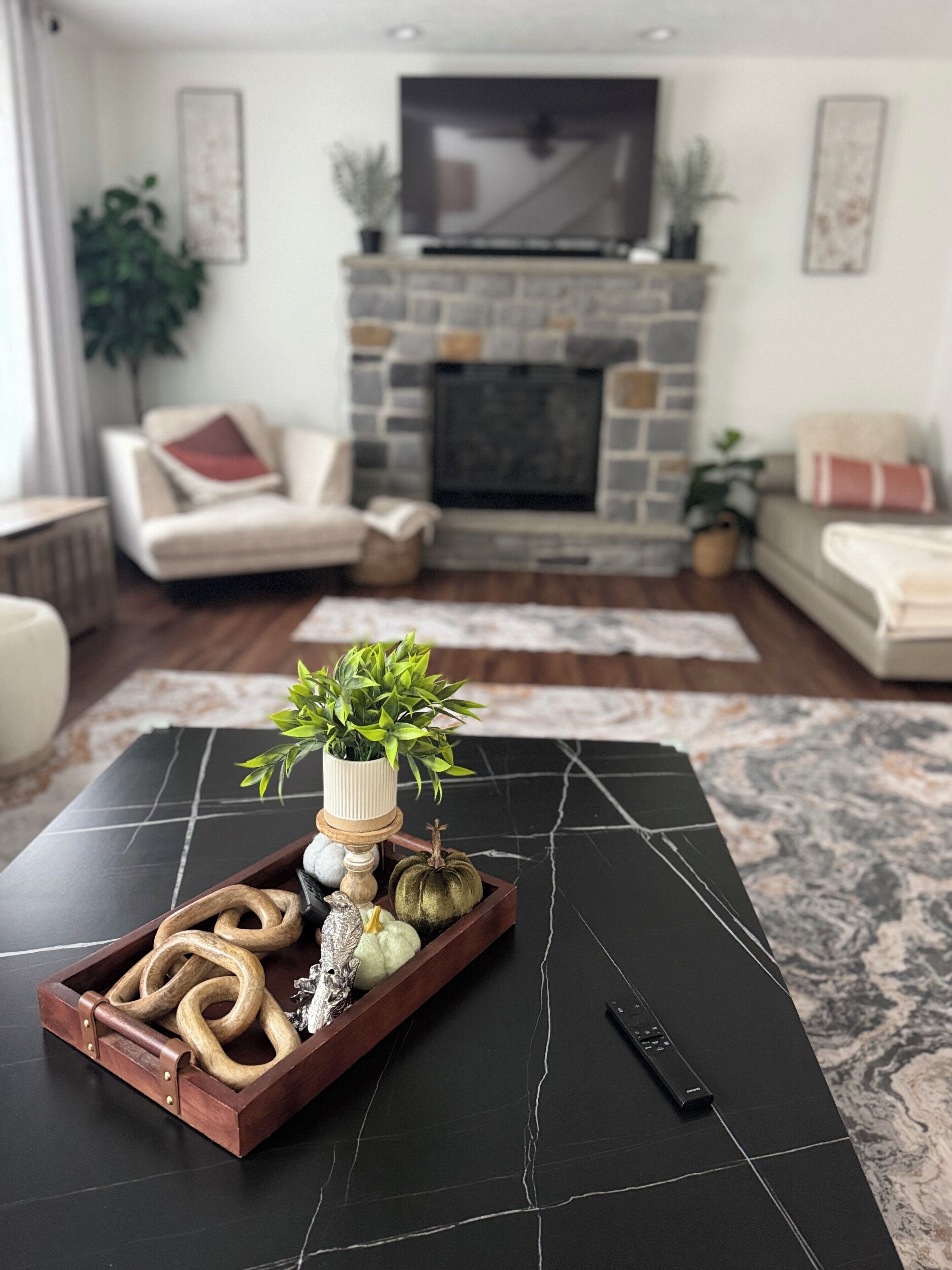 A modern living room with a black marble coffee table, a fireplace, and a sofa.