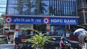 Um edifício moderno com fachada de vidro, um letreiro visível do restaurante 'Turtle Town' e uma agência do banco 'HDFC'.