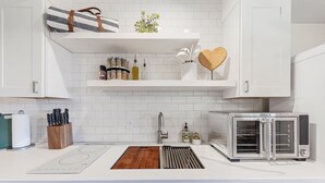 A modern kitchen with white cabinets, a built-in oven, a toaster, and a wooden cutting board. - Eagle, CO Private Mountain Retreat near Vail (Eagle)