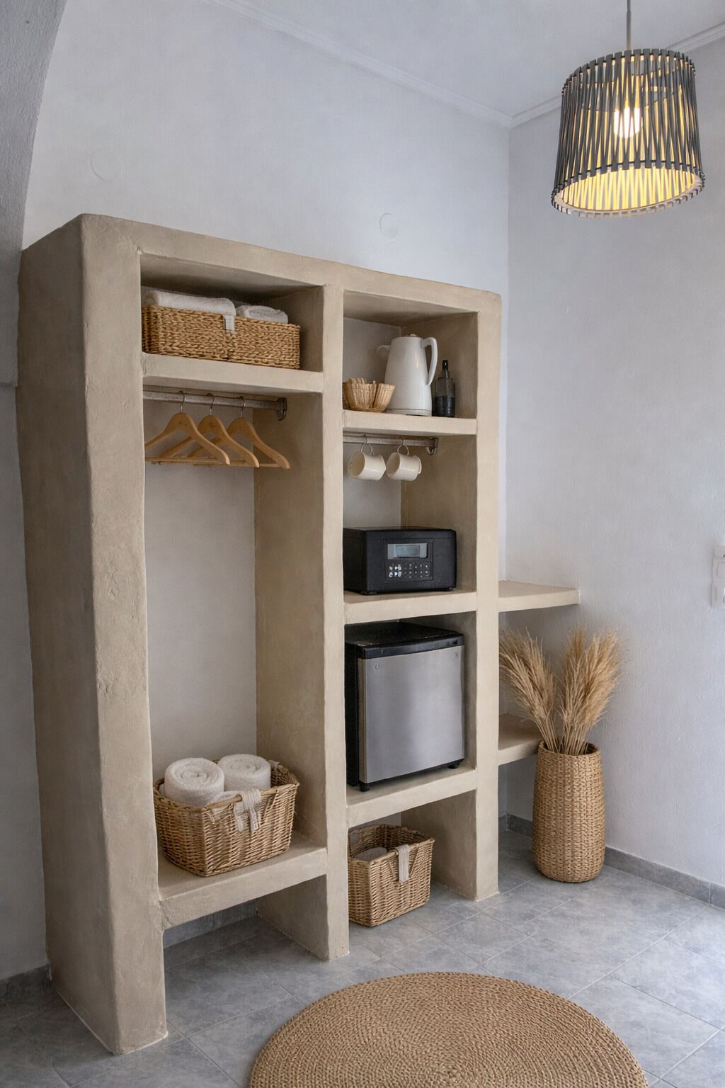 A concrete-built storage unit with shelves, baskets, and a coffee maker.