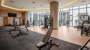 Een moderne sportschool met diverse fitnessapparaten, grote ramen en een overzichtelijke, ruime indeling.