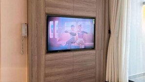 Een televisie bevestigd aan een houten wand in een hotelkamer.
