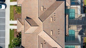 Vue aérienne d’un bâtiment doté d’un toit à motifs géométriques et de plusieurs balcons.