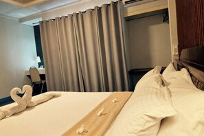 A hotel room with a bed, curtains, a desk, and a television. - Northomes Pensione Bogo By Hiverooms (Bogo City)