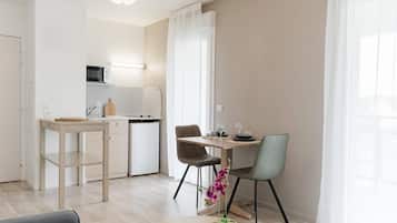 Une cuisine moderne équipée d’un four à micro-ondes, d’un évier et d’un coin repas avec une table et des chaises.
