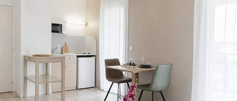 Una cocina moderna con microondas, un fregadero y un comedor con mesa y sillas.