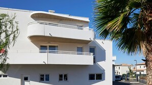 A modern multi-story building with balconies and a clear blue sky. - Quality Aparthotel Les rives de Mèze (Meze)