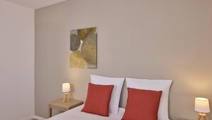 A hotel room with a bed, two nightstands, and a wall art piece.