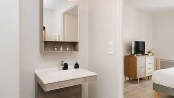 Ein modernes Badezimmer mit Waschbecken, Spiegel und Holzschrank.