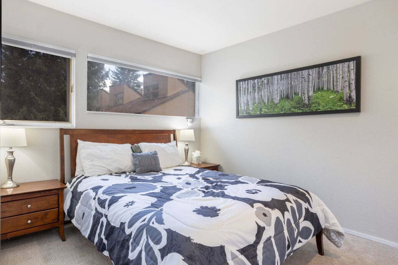 A bedroom with a large bed, two bedside tables, and a window.