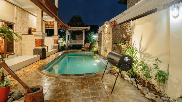 A swimming pool with a stone deck, a barbecue grill, and a pergola with seating. - Charming 8-bedroom guesthouse with shared kitchen, only 1 km from the beach. (Banjar)