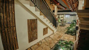 A stone staircase with wooden panels and a black railing leading to a second floor. - Charming 8-bedroom guesthouse with shared kitchen, only 1 km from the beach. (Banjar)