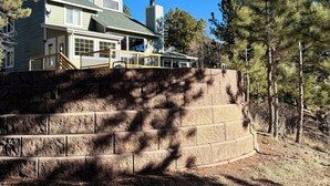 Una casa de dos pisos con una escalera de piedra que sube a una terraza.