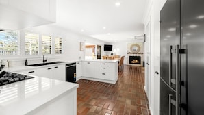 Una cocina moderna con armarios blancos, una isla central y una chimenea.
