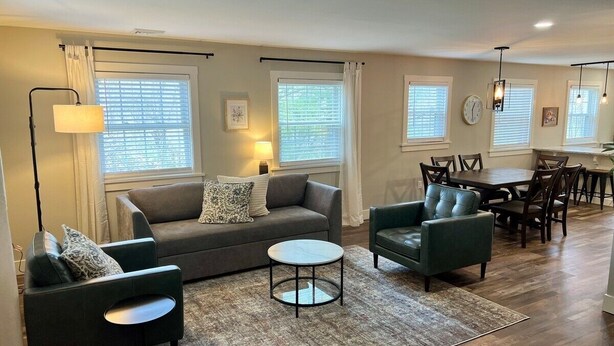 A modern living room with a grey sofa, two armchairs, a coffee table, and a dining area with a table and chairs. - Peaceful Home near Historic Strasburg (Lancaster)