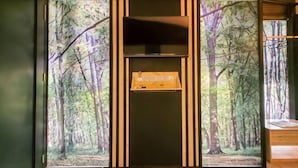 A room with a large window, a wooden cabinet, and a framed picture of a forest. - XChalet X Park Iskandar Puteri (Iskandar Puteri)