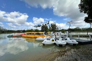Un lago tranquilo con varias embarcaciones y una hilera de sombrillas a lo largo de la orilla.