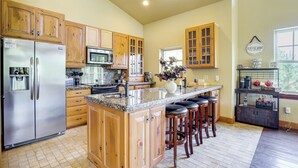 A kitchen with wooden cabinets, stainless steel appliances, a granite countertop, and a coffee bar area. - Grand Lake Waterfront Getaway w/ Boat Slip! (Eucha)