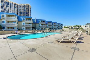 A rooftop pool area with lounge chairs and a swimming pool. - Steps to Sea! 3rd-Floor Myrtle Beach Condo w/ Pool (Myrtle Beach)