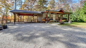 A rustic cabin with a covered porch, a gravel driveway, and a garden with potted plants. - Raft, Hike & Fish: Quiet Couple's Escape in Murphy (Murphy)