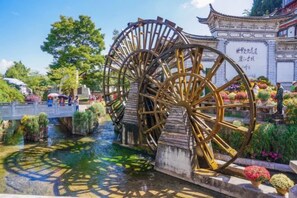 A traditional water wheel structure with a bridge in the background. - Anju·Rizhao Jinshan Designers' Panoramic Rooftop Cafe and Snow Mountain View (Lijiang)