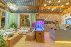 A modern living room with a sofa set, a television, and a reception desk. - Anju·Rizhao Jinshan Designers' Panoramic Rooftop Cafe and Snow Mountain View (Lijiang)