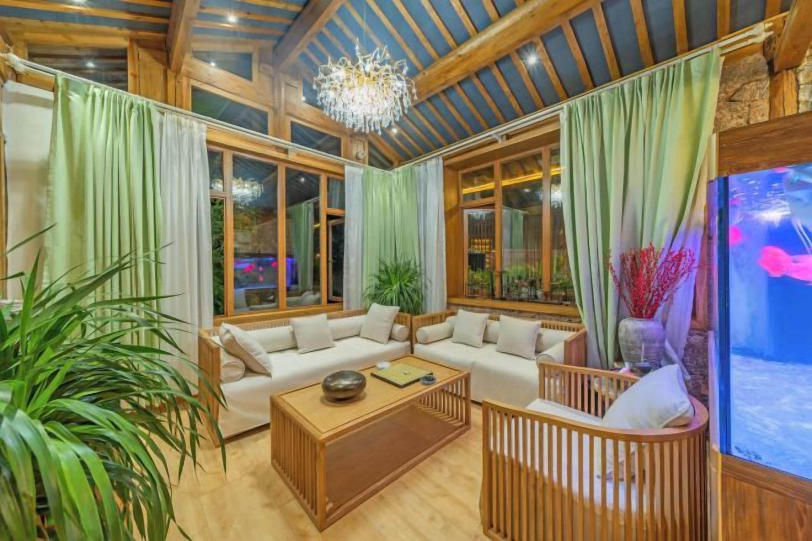 A spacious living room with a sectional sofa, a coffee table, and a large window with curtains.