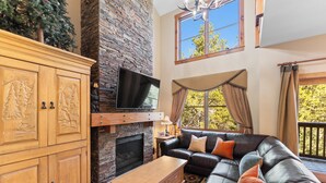A living room with a stone fireplace, leather sofa, and wooden cabinets. - Sk1841-2 (Keystone)